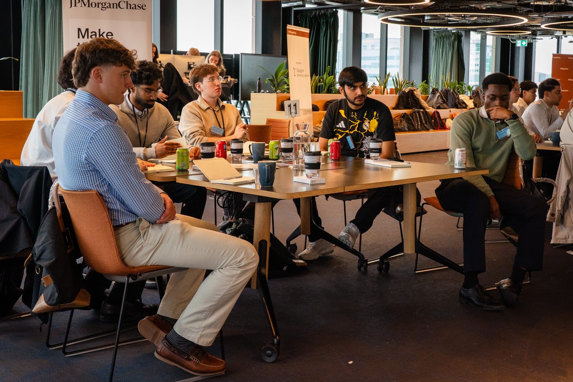 A group of people seated around a table in a modern open-plan office.